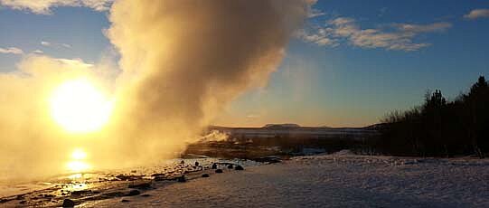 Beach with clouds and smoke at sunrise.